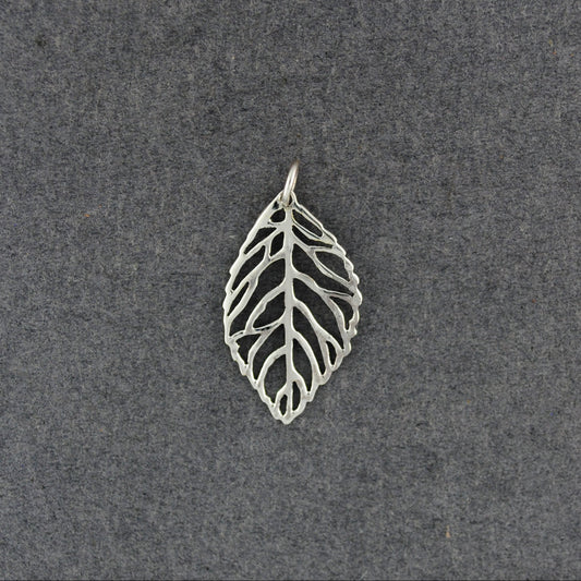 A silver leaf-shaped pendant with an openwork, vein-like design, displayed on a textured dark gray background.